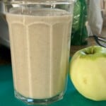 Glass with Apple Almond Protein Shake with Peeled Apple Alongside