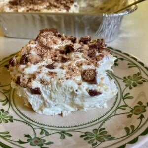 easy creamy toffee crunch dessert made lighter on decorative dessert plate shot from front, pan of dessert in background