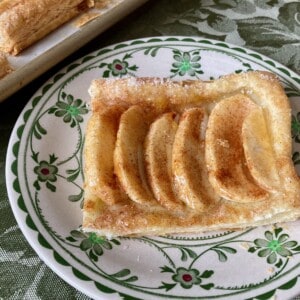 Low Calorie Apple Pie Pastry Square on decorative plate with pan of squares in background