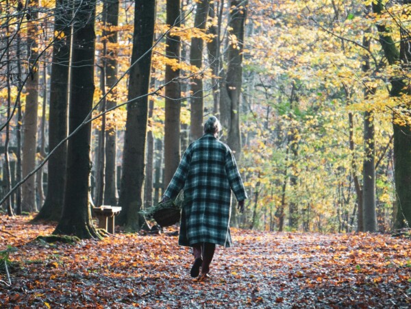 woman walking leaf covered path