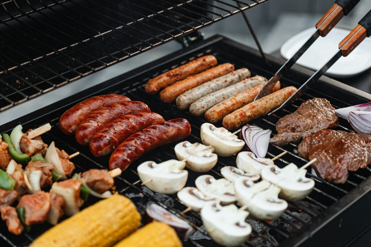 Grilling kebabs, hot dogs, sausages, corn on the cob and vegetables.