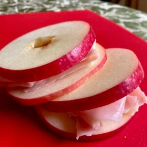 2 Apple, Ham & Cheese "Sandwiches" on red cutting board