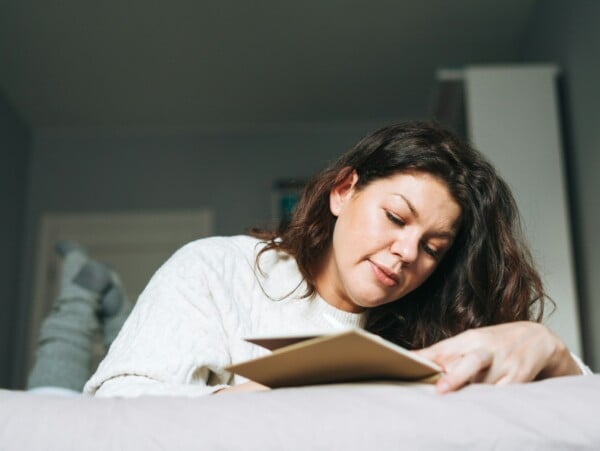 Brunette woman white top journaling