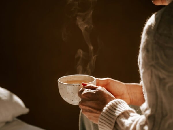 woman in sweater drinking cup of tea