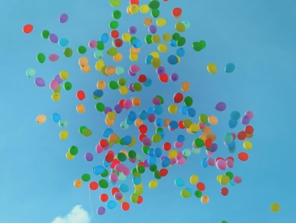 multicolored balloons floating in clear blue sky