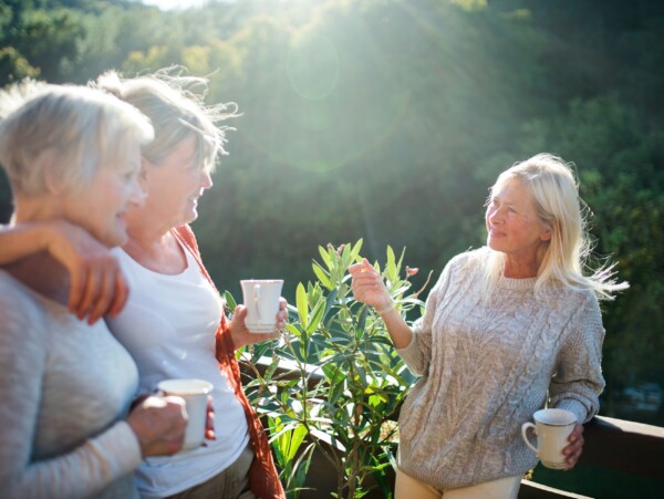 3 older lady friends visiting outside on a deck