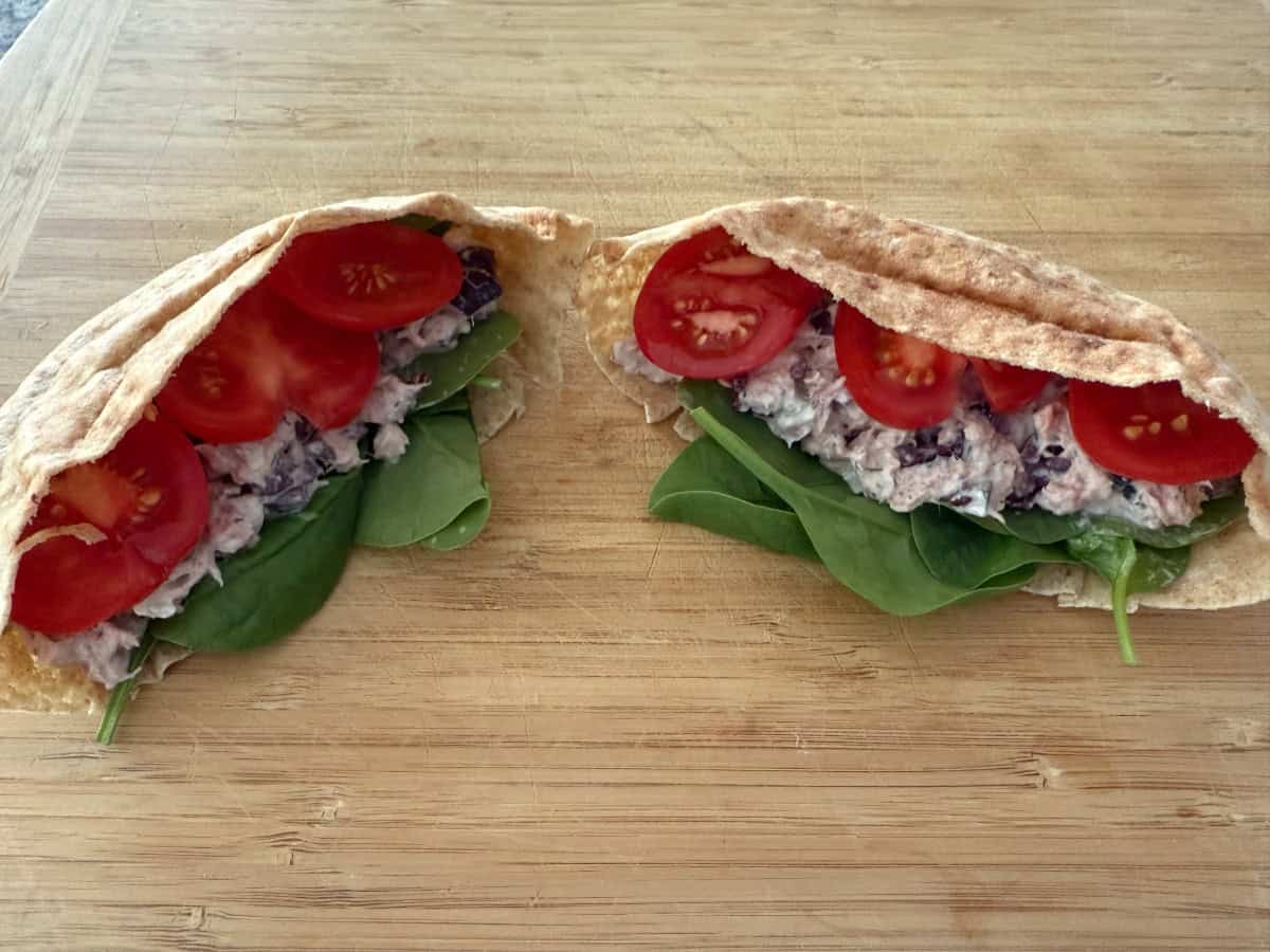 Greek Tuna Salad Stuffed Pita Pocket on wood cutting board.