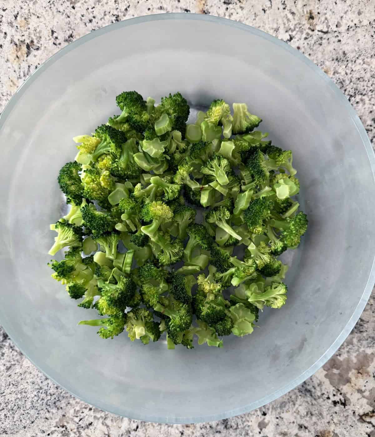 Broccoli florets in a glass bowl.