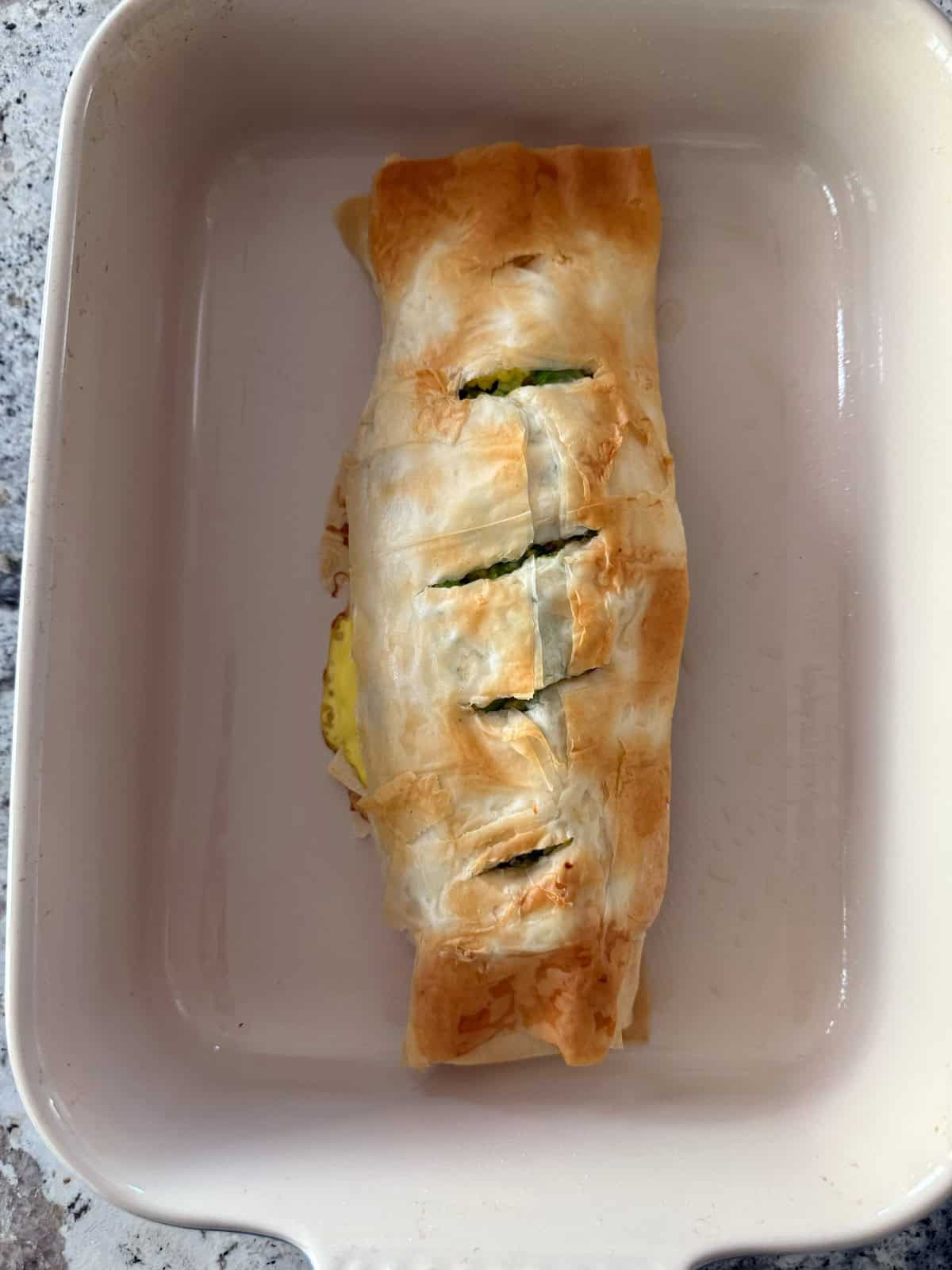 Fresh baked egg and broccoli strudel in baking dish.