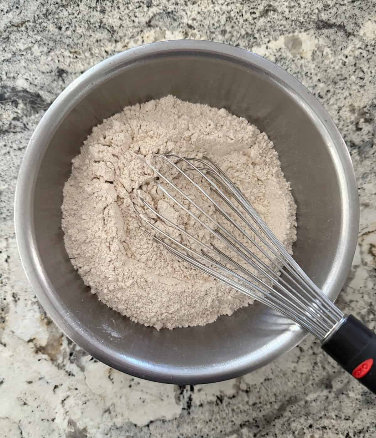 Whisking all-purpose flour, cinnamon, nutmeg and ginger in a mixing bowl.