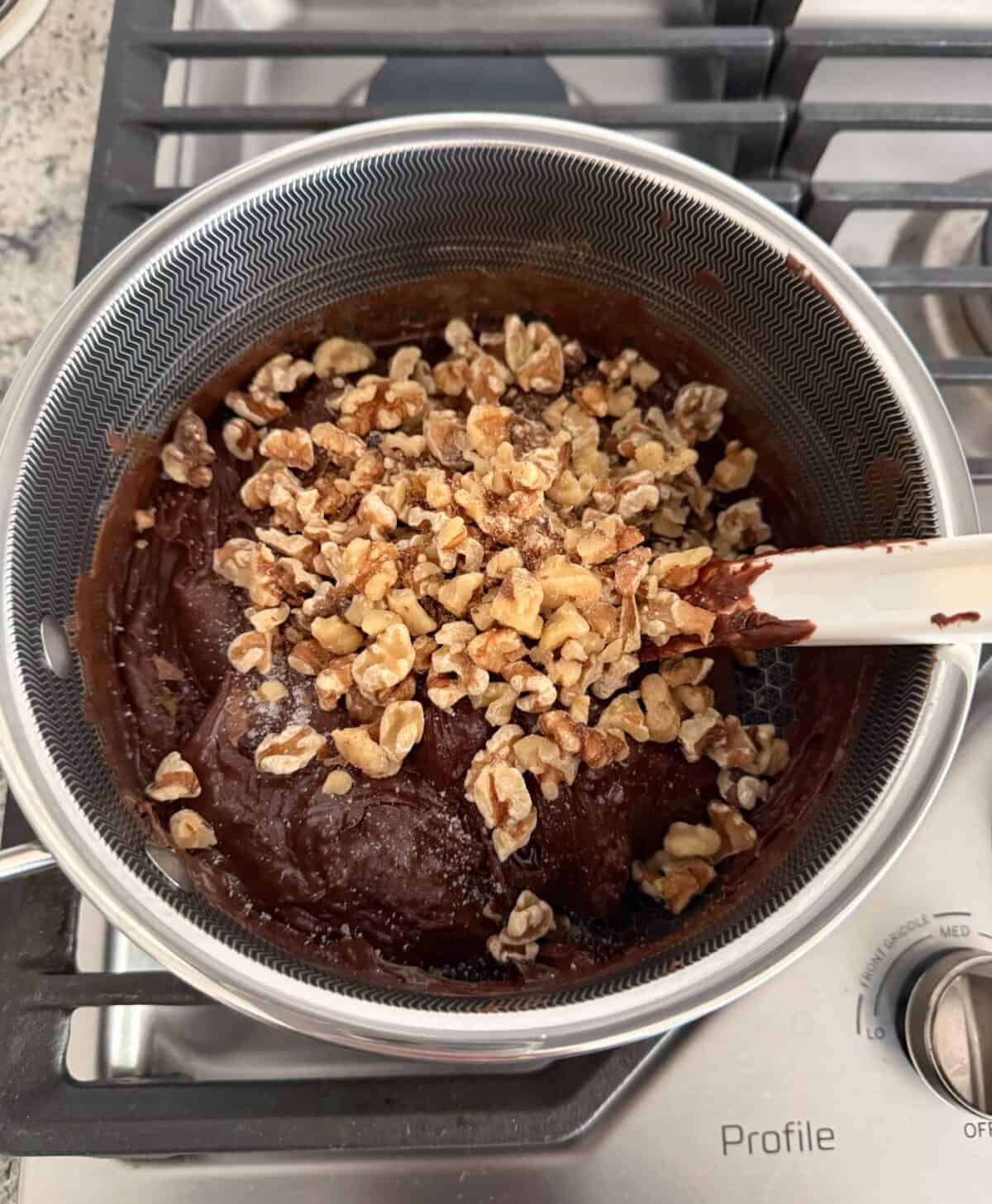 Mixing chocolate walnut fudge batter in sauce pan.